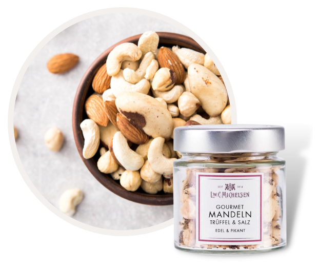 Ein Glas mit Gourmet Nüssen und Mandeln, gewürzt mit Trüffel und Salz, daneben eine Schale mit verschiedenen Nüssen.