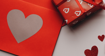 Rotes Geschenk mit Herzmotiv und passender Karte mit Herzdesign