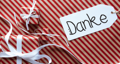 Geschenk in rot-weißer Streifenverpackung mit einem 'Danke'-Schild und weißem Band
