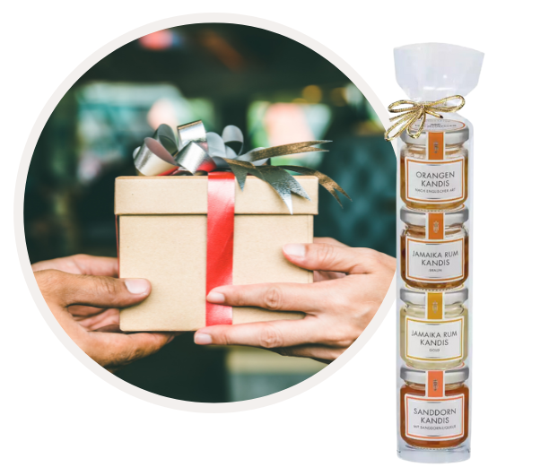 Ein Geschenkset mit mehreren Gläsern, das Orangenkandis, Jamaika Rum Kandis und Sanddornkandis enthält, daneben eine Person, die ein Geschenk mit Schleife überreicht.