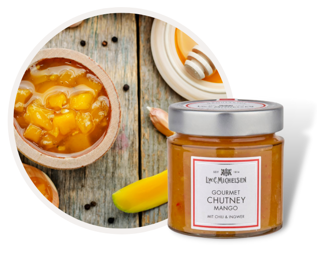 Glas L.W.C. Michelsen Gourmet Mango Chutney mit Chili und Ingwer neben einer Schale frisches Chutney auf Holztisch
