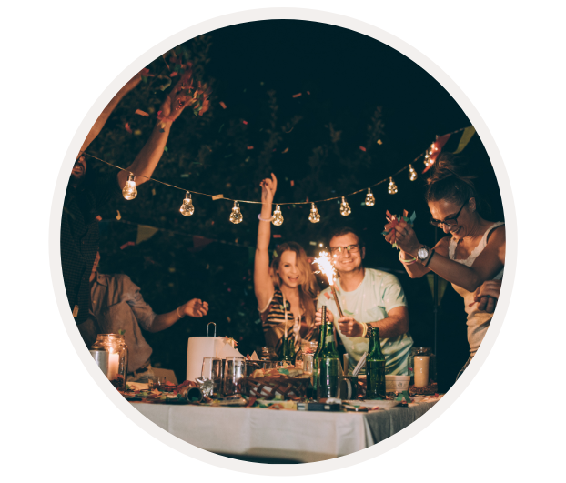 Gruppe von Menschen, die nachts unter Lichterketten feiern