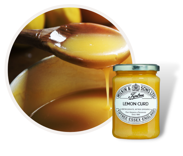 Ein Glas Tiptree Lemon Curd neben einem Löffel voller cremiger Zitronencreme