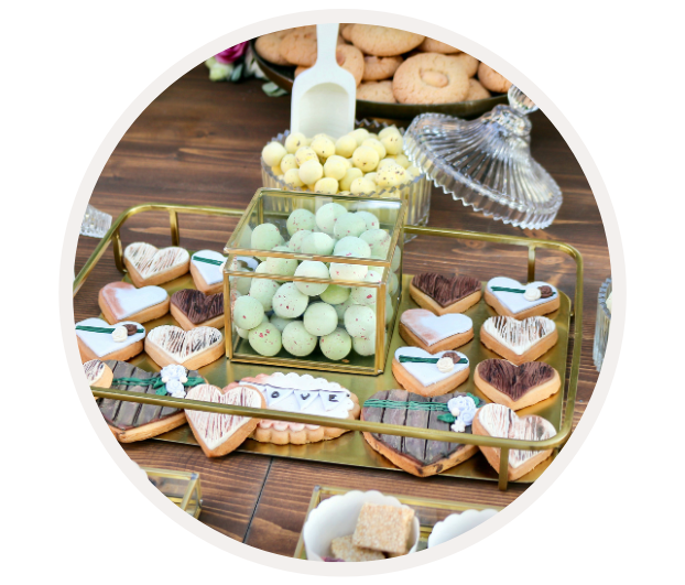 Ein Tablett mit herzförmigen Keksen und bunten Schokoladeneiern, dekoriert für eine Feier.