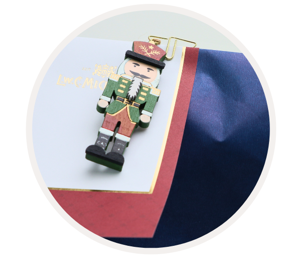 Ein Holzsoldat in traditioneller Uniform dekoriert eine in Blau und Rot gehüllte Geschenkverpackung.