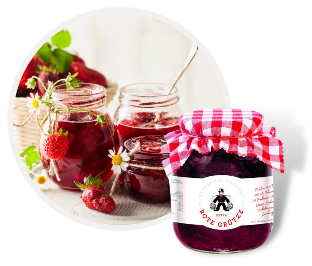 Verschiedene Gläser mit hausgemachter roter Grütze, dekoriert mit frischen Erdbeeren und Kamilleblüten