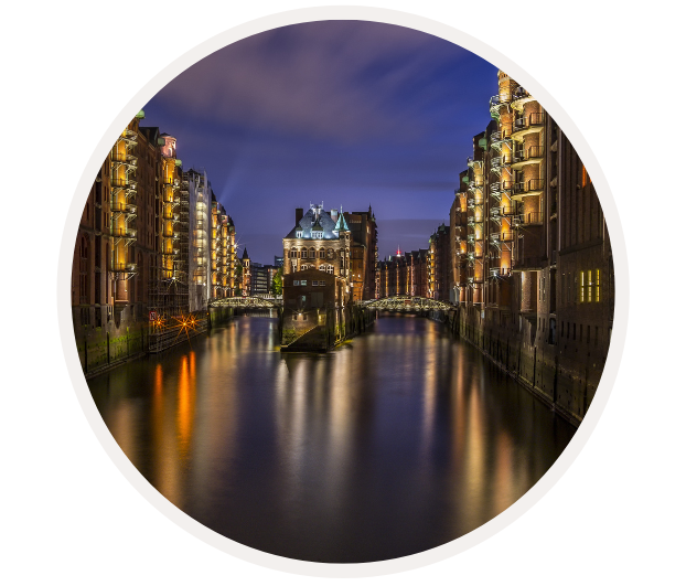 Abendliche Aufnahme der Hamburger Speicherstadt mit beleuchteten historischen Gebäuden und Kanälen