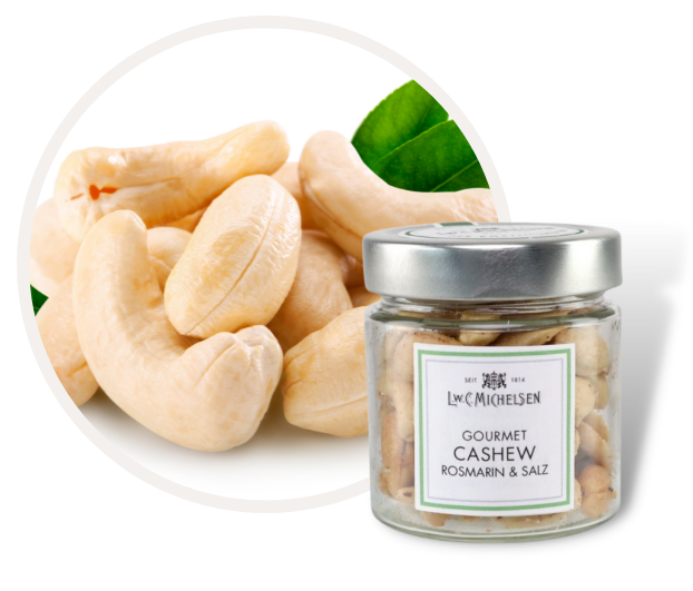 Nahaufnahme von Cashewkernen und einem Glas mit der Aufschrift 'Gourmet Cashew Rosmarin & Salz'