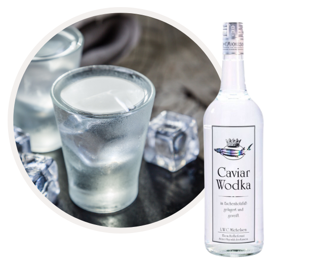 Flasche Kaviar Wodka neben einem Glas mit Eiswürfeln
