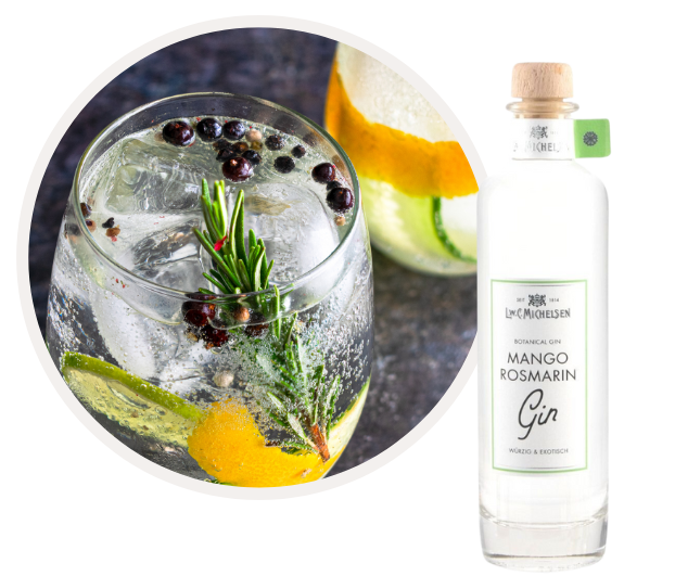 Flasche Mango Rosmarin Gin neben einem Glas Gin Tonic mit Rosmarin, Wacholderbeeren und Zitronenschale, serviert auf Eis.