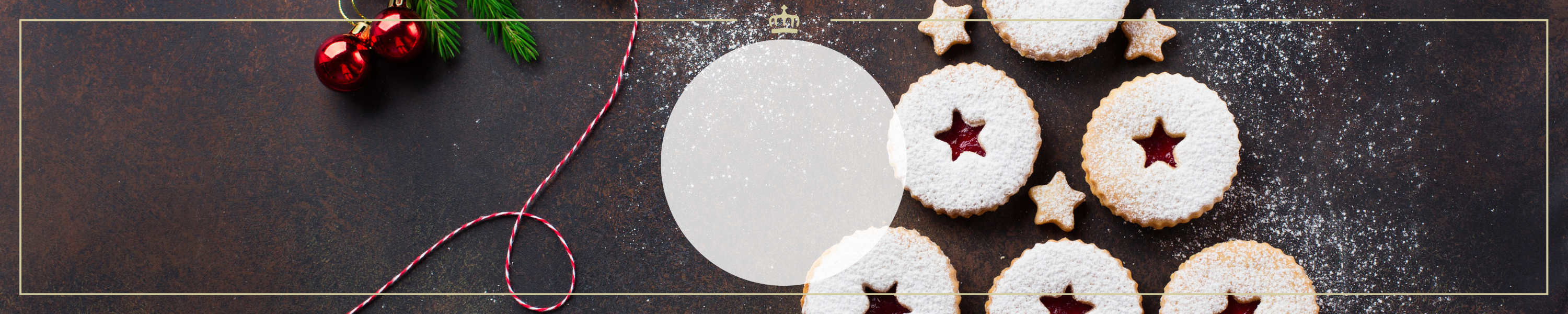 Festliche Weihnachtskekse mit roter Marmeladenfüllung und Zuckerguss, dekoriert mit kleinen Sternkeksen und Tannenzweigen im Hintergrund