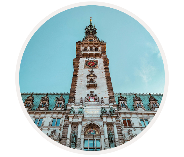 Frontale Ansicht des prächtigen Hamburger Rathauses mit Turmuhr und blauer Himmel im Hintergrund