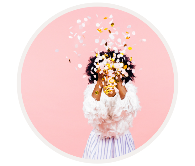 Frau mit lockigem Haar wirft festliches Konfetti in die Luft, Hintergrund in Pastellrosa