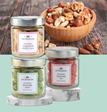 Verschiedene Gourmet-Nüsse und Wasabi-Snacks in Gläsern vor einer Schale mit gemischten Nüssen.