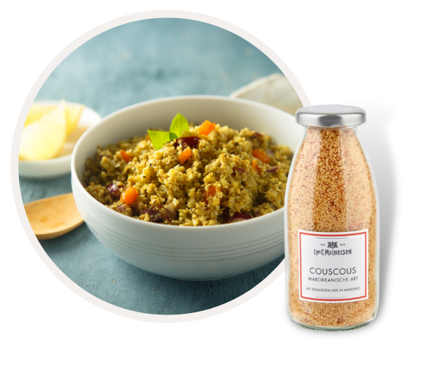 Schüssel mit gewürztem marokkanischen Couscous neben einer Glasflasche mit Couscous.